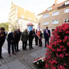 Kwiaty pod pomnikiem ks. Popiełuszki i tablicą Solidarności