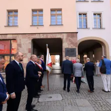 Kwiaty pod pomnikiem ks. Popiełuszki i tablicą Solidarności