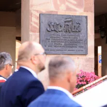 Kwiaty pod pomnikiem ks. Popiełuszki i tablicą Solidarności