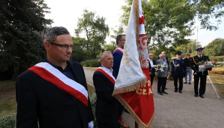Kwiaty pod pomnikiem ks. Popiełuszki i tablicą Solidarności