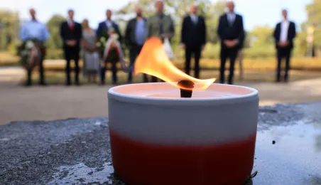 Kwiaty pod pomnikiem ks. Popiełuszki i tablicą Solidarności