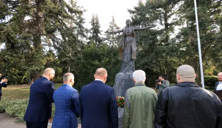 Kwiaty pod pomnikiem ks. Popiełuszki i tablicą Solidarności