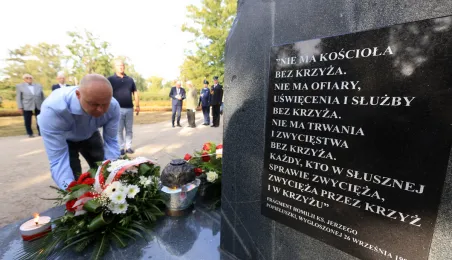 Kwiaty pod pomnikiem ks. Popiełuszki i tablicą Solidarności