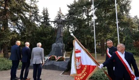 Kwiaty pod pomnikiem ks. Popiełuszki i tablicą Solidarności