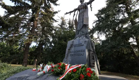 Kwiaty pod pomnikiem ks. Popiełuszki i tablicą Solidarności