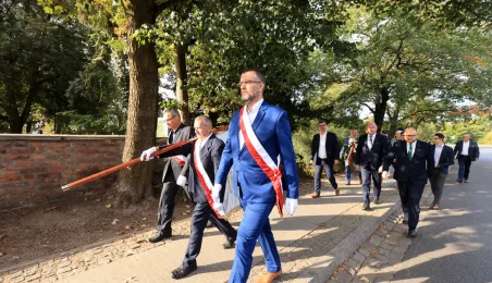 Kwiaty pod pomnikiem ks. Popiełuszki i tablicą Solidarności