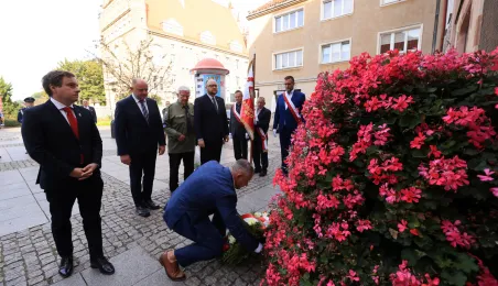 Kwiaty pod pomnikiem ks. Popiełuszki i tablicą Solidarności