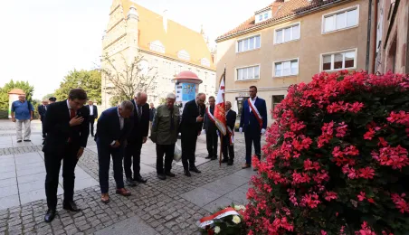 Kwiaty pod pomnikiem ks. Popiełuszki i tablicą Solidarności