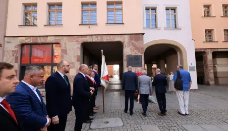 Kwiaty pod pomnikiem ks. Popiełuszki i tablicą Solidarności