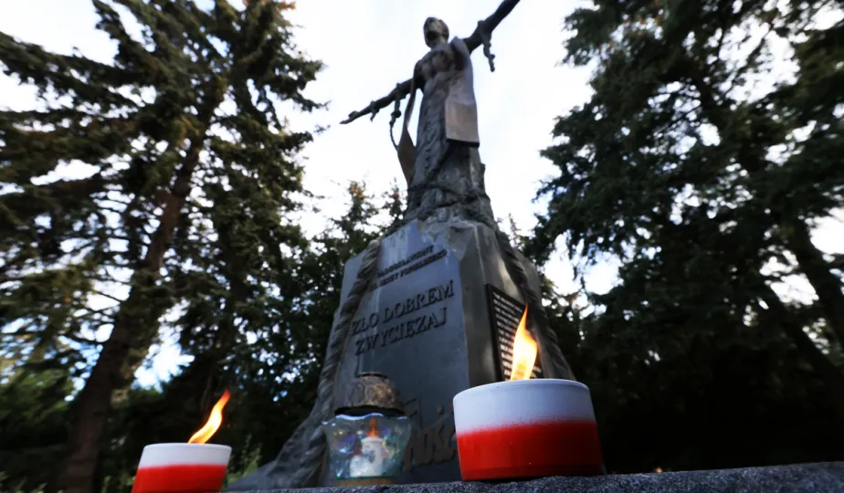 Kwiaty pod pomnikiem ks. Popiełuszki i tablicą Solidarności