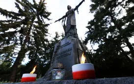 Kwiaty pod pomnikiem ks. Popiełuszki i tablicą Solidarności