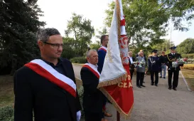 Kwiaty pod pomnikiem ks. Popiełuszki i tablicą Solidarności