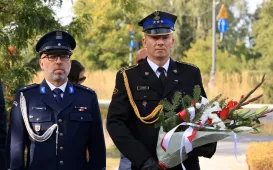 Kwiaty pod pomnikiem ks. Popiełuszki i tablicą Solidarności