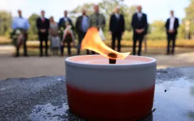 Kwiaty pod pomnikiem ks. Popiełuszki i tablicą Solidarności