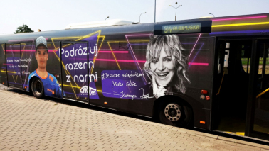 Na zdjęciu autobus z reklamą „Podróżuj razem z nami” z wizerunkiem Katarzynky Żak i Adriana Miedzińskiego 