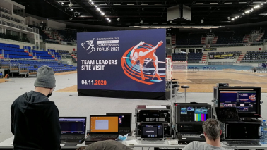 W hali Arena Toruń ustawiony jest duży ekran, na którym wyświetlkane są prezentacje o Toruniu i hali, na pierwszym planie stół techniczny, skąd całość jest transmitowana do uczestników spotkania