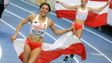 Polskie biegaczki cieszą się po zwycięskim biegu, trzymają flagi Polski