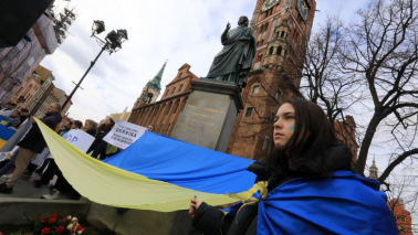 Na zdj: dziewczyna trzyma flagę Ukrainy,a w tle znajduję się pomnik Mikołaja Kopernika