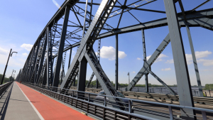 Na zdjęciu: fragment rozbudowanego mostu drogowego, widać czerwoną nawierzchnięścieżki rowerowej