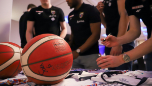 Na zdjęciu: zawodnicy Twardych Pierników podpisują koszulki, na pierwszym planie piłka koszykarska