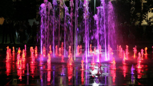 Na zdjęciu: woda tryskająca z fontanny w kolorach czerwonym i fioletowym