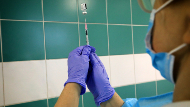 Na zdjęciu widać pielęgniarke trzymającą strzykawkę napełniona szczepionką
