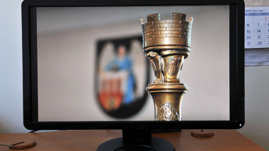 Na zdjęciu: laska przewodniczące i herb Torunia na ekranie komputera