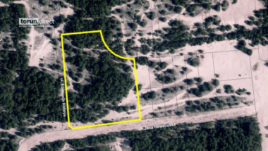 Widok z drona na tereny leśne na północy Torunia z zaznaczonym terenem inwestycyjnym