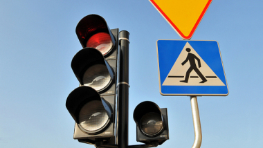 Na zdjęciu: sygnalizacja świetlna, obok znak drogowy informujący o przejściu dla pieszych