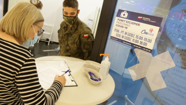 Na zdjęciu osoba wypełnia formularz przed punktem szczepień