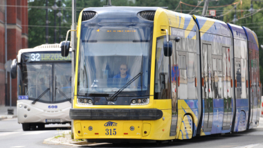 Na zdjęciu: żółty tramwaj i biały autobus miejski