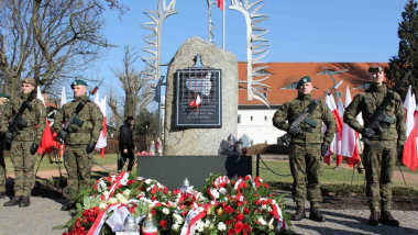 Na zdjęciu: pomnik upamiętniający Żołnierzy Wykletych, obok stoją żołnierze, przed pomnikiem leżą wieńce