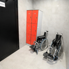 Na zdjęciu pomieszczenie socjalne z dwoma wózkami inwalidzkimi oraz szafkami na klucze