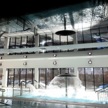 Na zdjęciu baseny rehabilitacyjne z tryskającym wodą parasolem wodnym oraz ich odbicie w czarnym, lustrzanym suficie