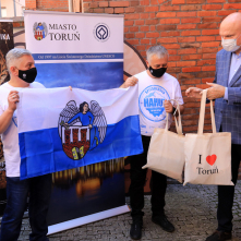 Na zdjęciu Ryszard Kruk oraz prof. Ireneusz Sobota trzymają flagę Torunia