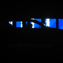 Samochód z widzami na tle oświetlonej na niebiesko ściany