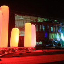 Instalacja świetlna złożona z przypominających świetlówki balonów, w tle zabytkowy tramwaj