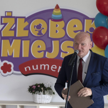 Prezydent Michał Zaleski przemawia podczas uroczystości otwarcia żłobka, w tle, na ścianie znajduje się kolorowy napis 