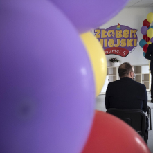 Na pierwszym planie widnieje fioletowy balon, w tle widać przemawiającego prezydenta Michała Zaleskiego