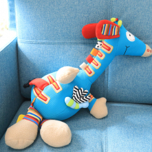 Kolorowa maskotka sensoryczna - stworek siedzi na niebieskim fotelu