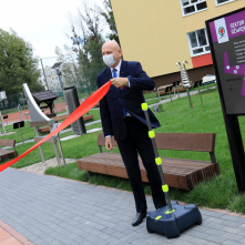 Na zdjęciu prezydent Michał Zaleski trzyma wstęgę przy ścieżce sensorycznej