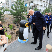 Na zdjęciu prezydent Michał Zaleski wyrzuca śmieci do śmietnika w kształcie pingwina