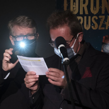 Na zdjęciu Marek Żydowicz podświetla telefonem kartkę Krzysztofowi Stanisławskiemu 