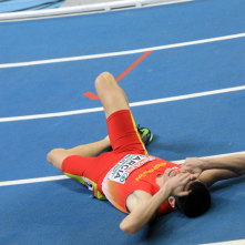 Po biegu na 800 m zawodnik hiszpański leży na bieżni z twarzą w dłoniach.