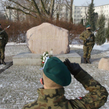 Na zdjęciu: żołnierz salutujący przed obeliskiem