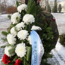 Na zdjęciu: żołnierz niosący wieniec kwiatów