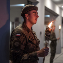 Na zdjęciu żołnierz trzyma pochodnię