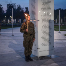 Na zdjęciu żolnierz z pochodnią przy tablicy w Parku Pamięci Narodowej