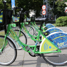 Kilka zielono-niebieskich rowerów na stacji wypożyczeń
