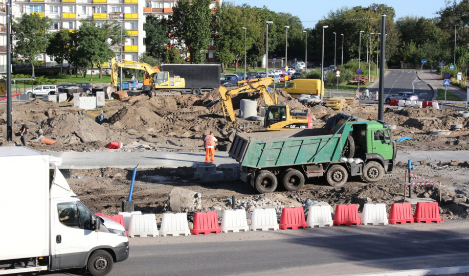 Zielona ciężarówka i czerwono-biała przegroda na tle rozkopów placu Niepodległości
